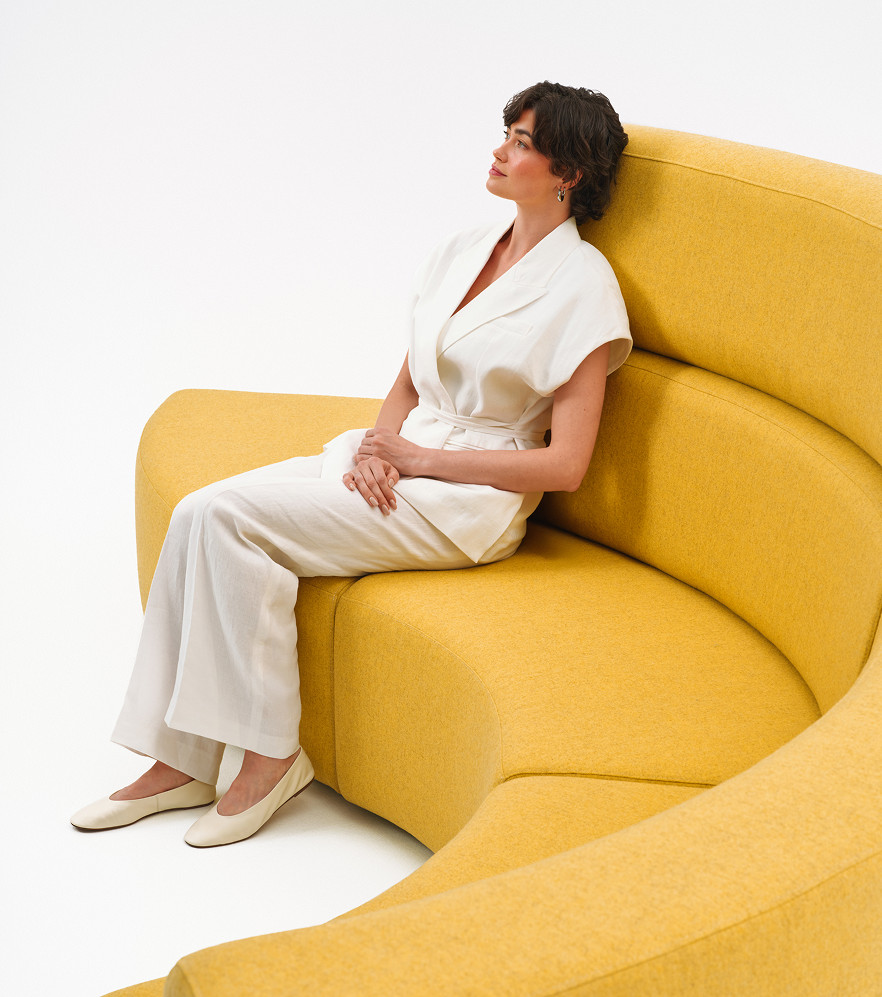 Woman sitting on modular breakout seating in a studio setting