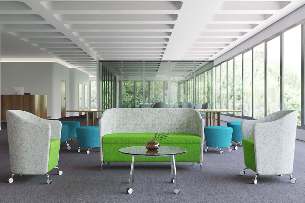 Modern office breakout area with modular seating, stools, and a glass table