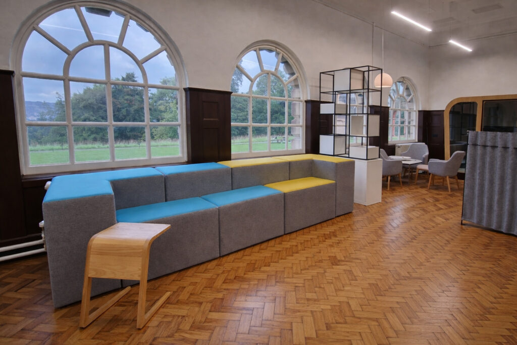 Office breakout area with modular seating and acoustic office pod