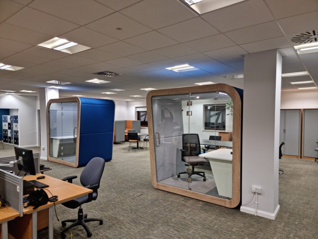 Office breakout area with two acoustic office pods and office desks