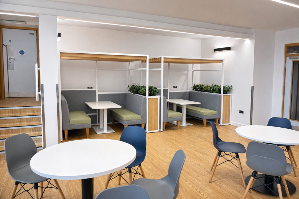 Office breakout area with modular seating booths and round tables