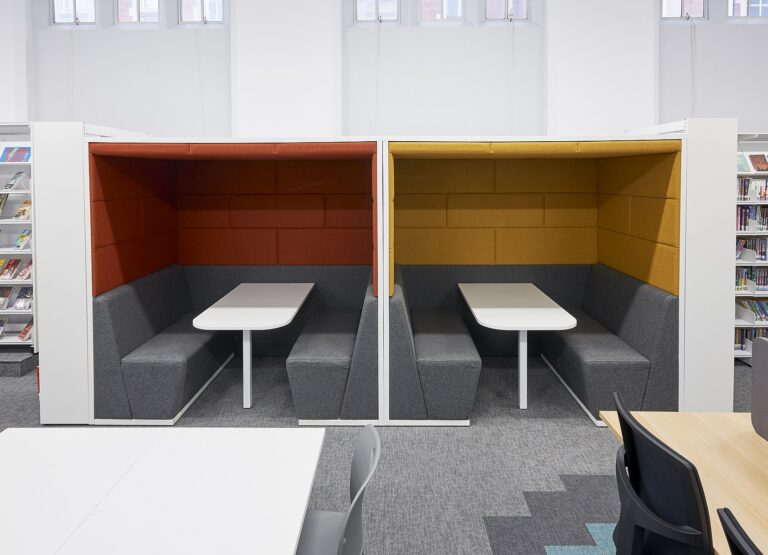 Two Session acoustic meeting booths with tables and modular seating in a breakout area